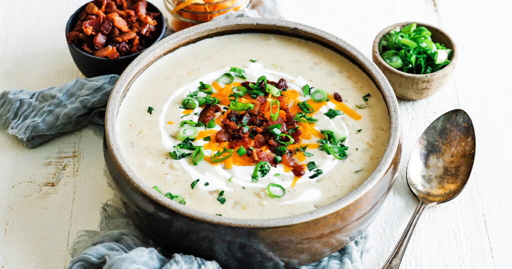 creamy potato soup in a bowl with cheese and green onions
