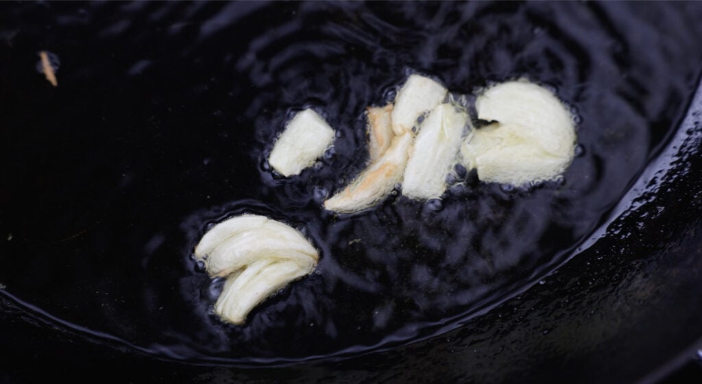 Garlic browning in a pot with olive oil