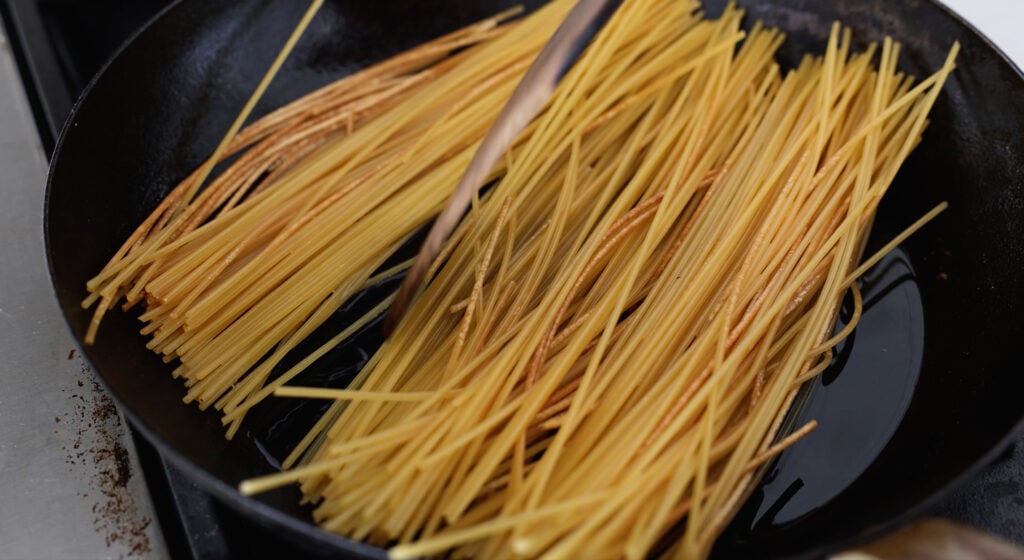Noodles spread out in a skillet 