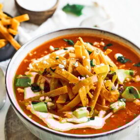 bowl of tortilla soup with crema and avocado