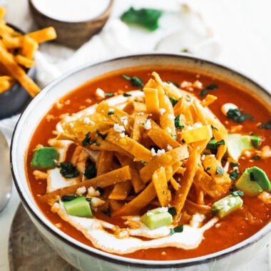 bowl of tortilla soup with crema and avocado