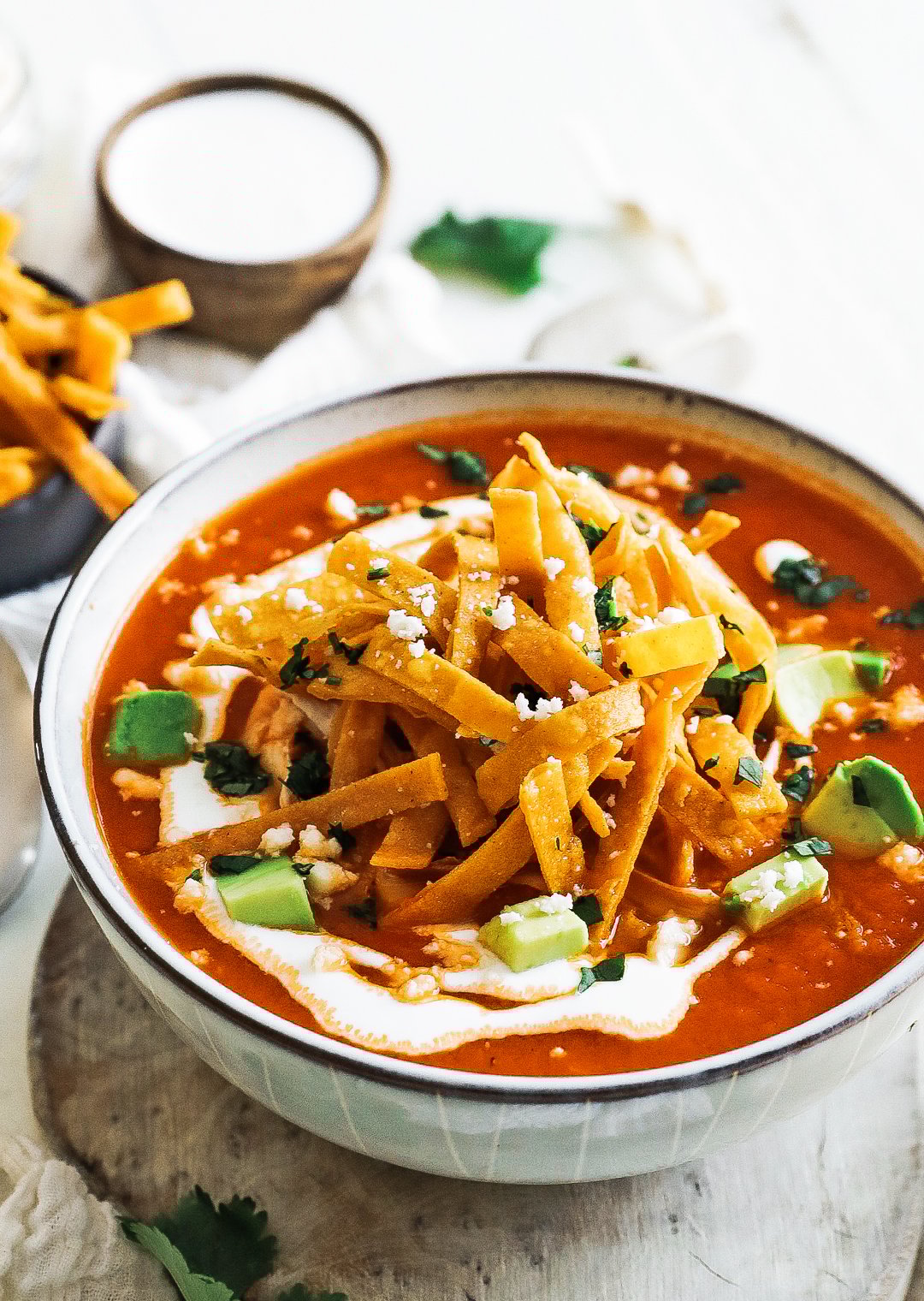 bowl of tortilla soup with crema and avocado