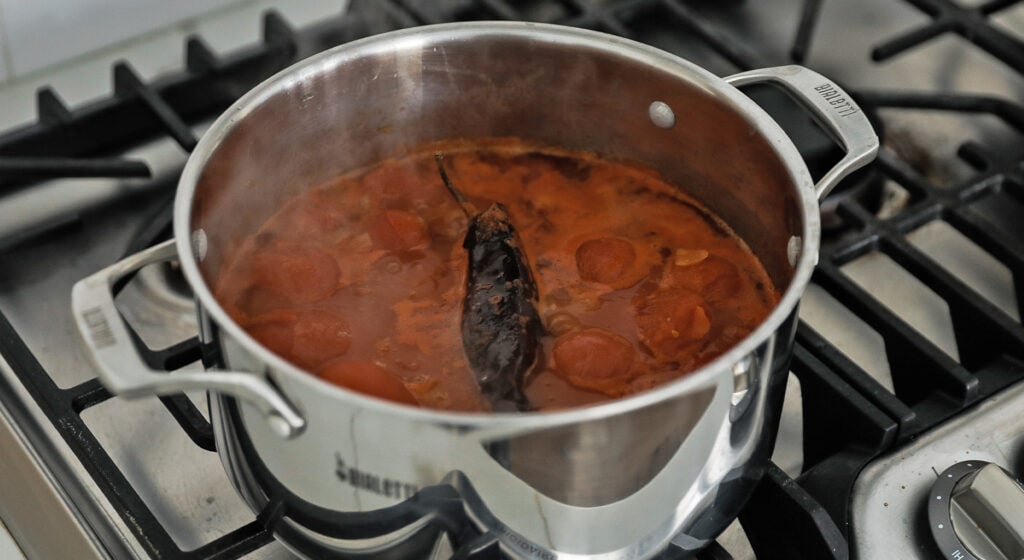 cooking tortilla soup with a pepper in a pot