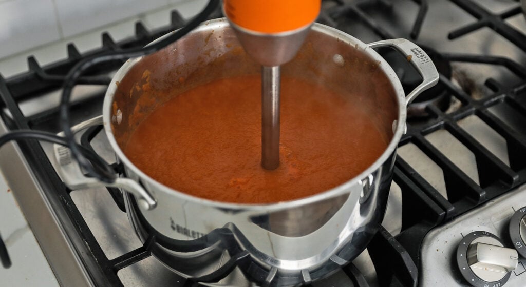 pureeing a tortilla soup with a hand blender