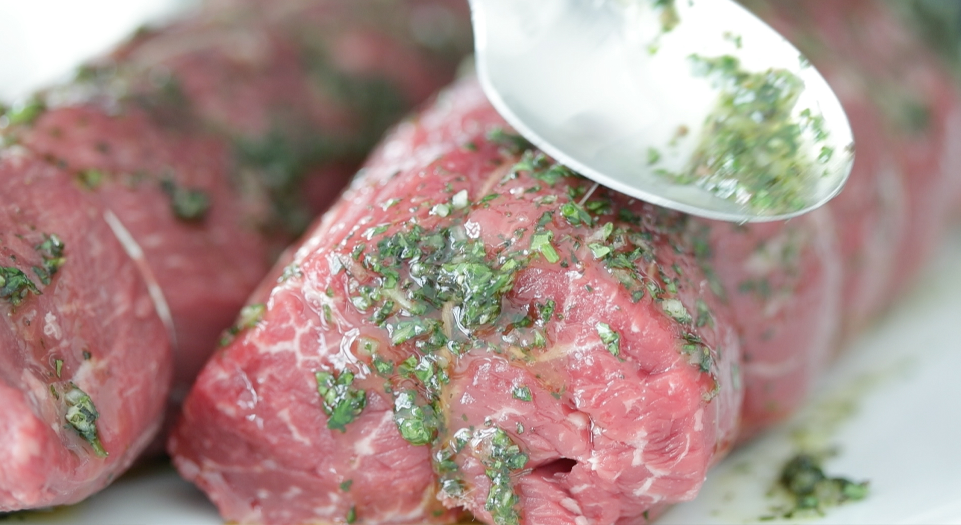 adding chimichurri to beef tenderloin