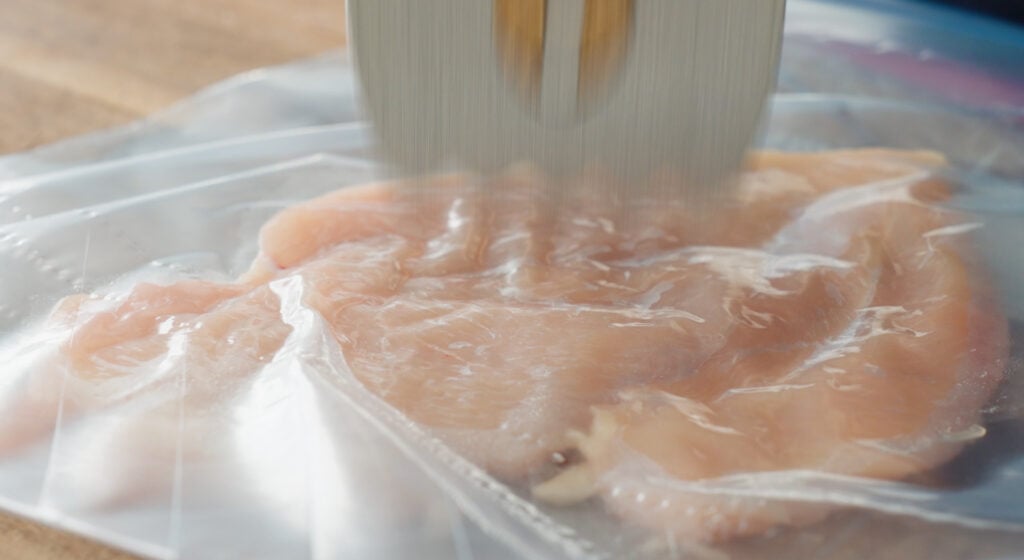 Pounding chicken breast with a meat mallet