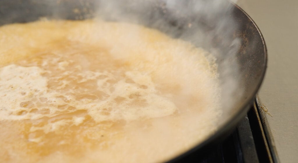 skillet with chicken broth steaming