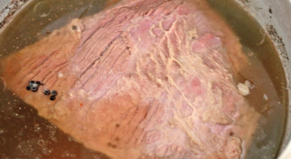 cooked corned beef in a pot of water