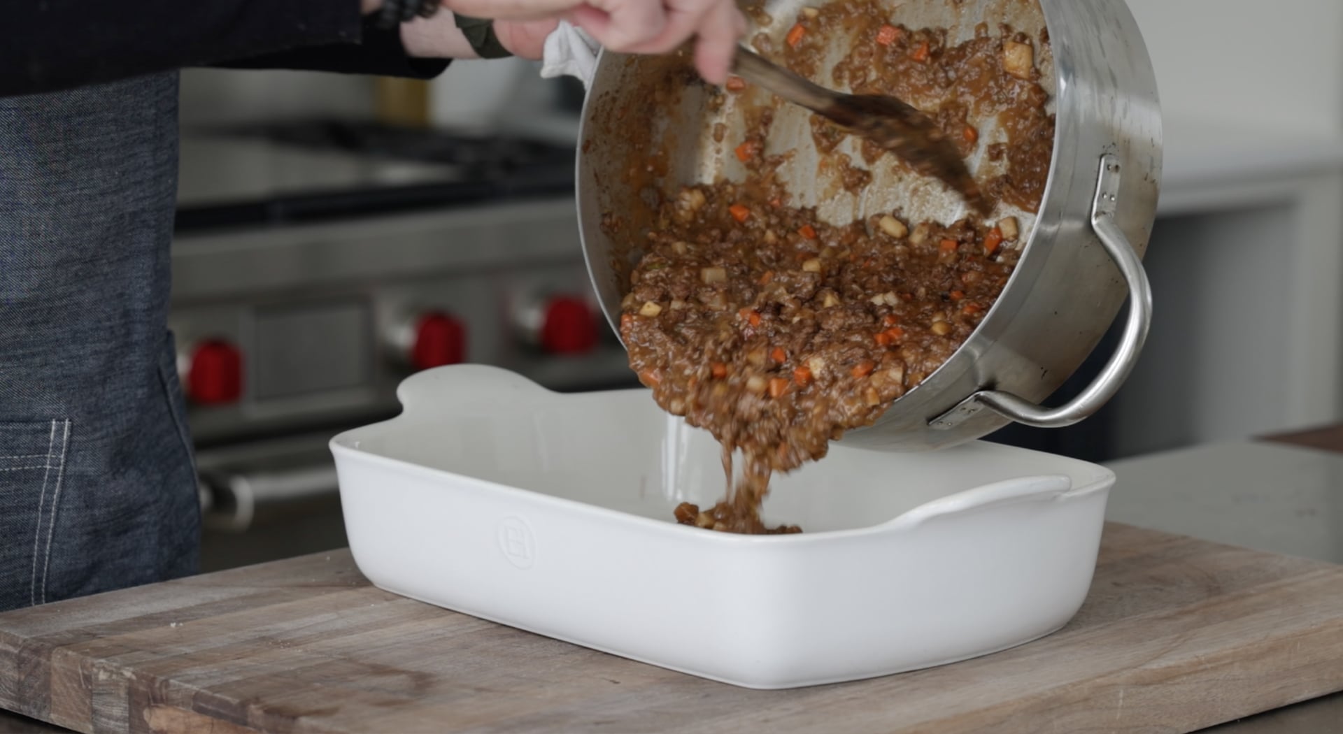 adding cottage pie filling to a casserole dish
