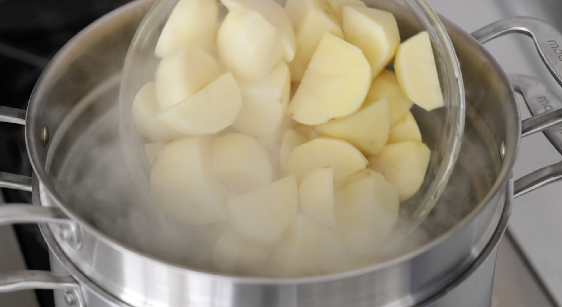 adding potatoes to boiling water
