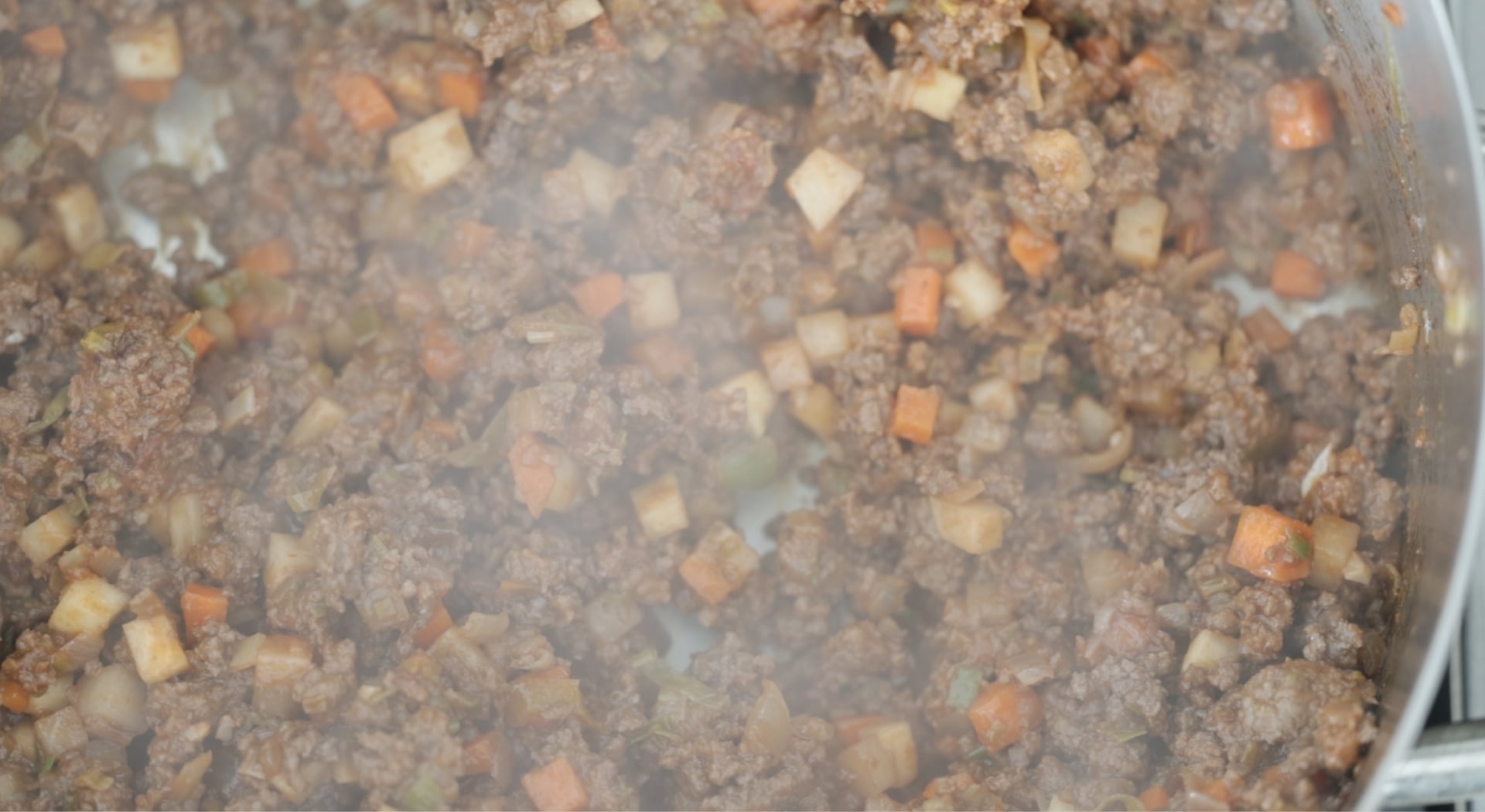 mixing in tomato paste to beef and vegetables