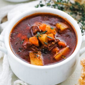 cup of beef stew with fresh herbs