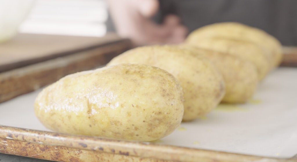 oil and salt coated potatoes on a baking sheet