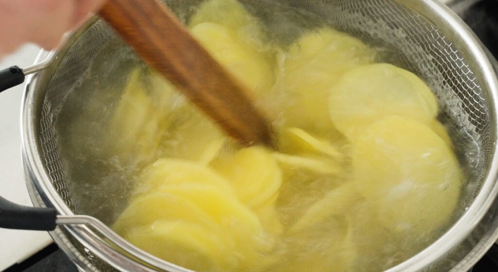 sliced potatoes in a pot of water