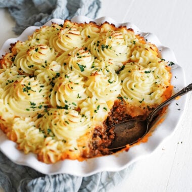 shepherd's pie in a white casserole dish with parsley