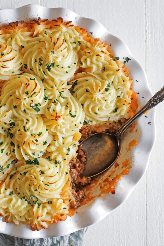 scooping shepherd's pie out of a dish