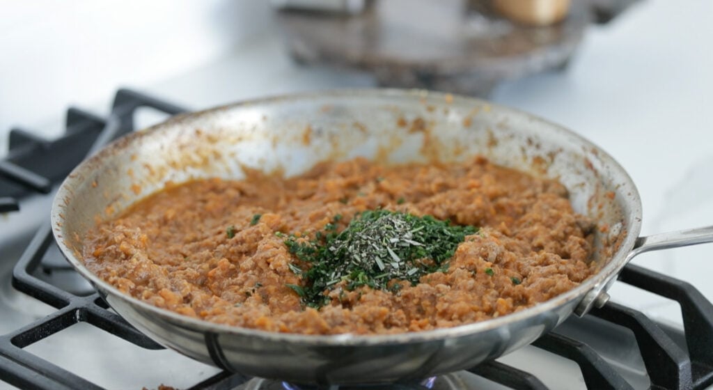 making shepherd's pie stuffing in a pan with herbs