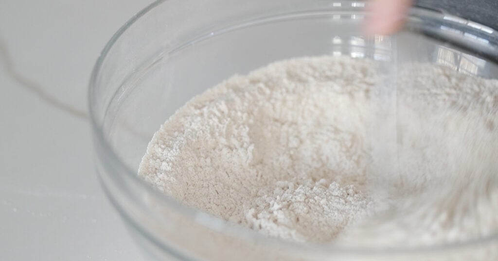 whisking together flours in a bowl