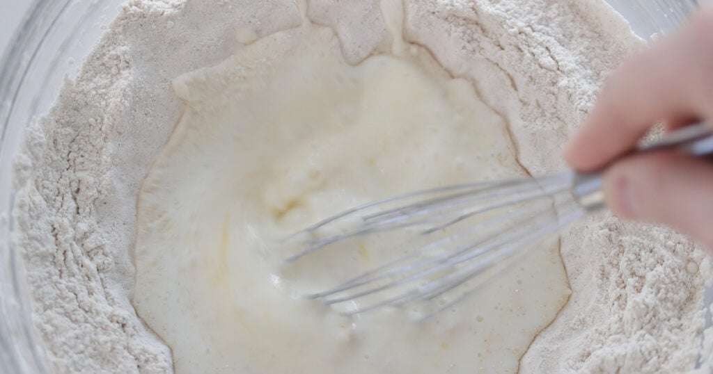 whisking together milk and flour in a bowl