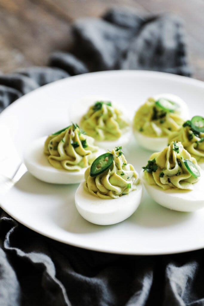avocado deviled eggs with cilantro on a plate