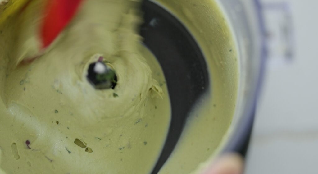 adding onion and cilantro to an avocado deviled egg filling