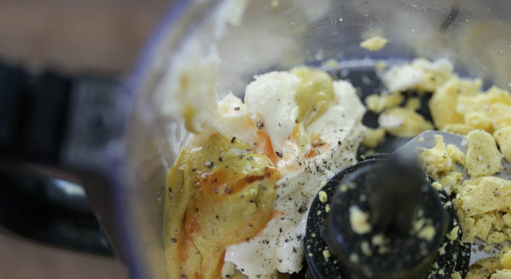 adding mustard to a food processor