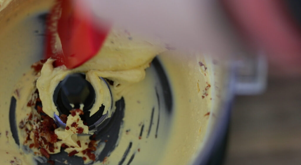 folding in bacon to a deviled egg filling