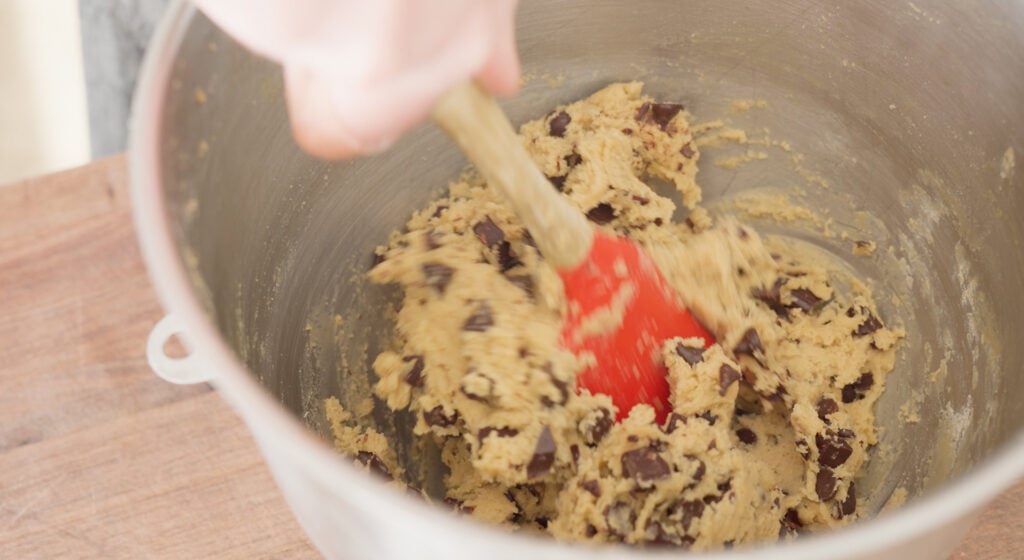 Using a spatula to fold in chocolate chips