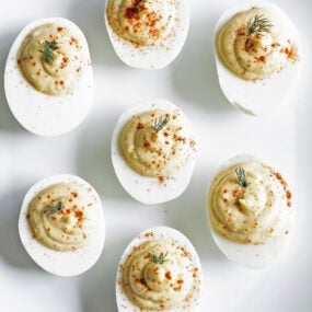 deviled eggs on a plate with paprika and dill