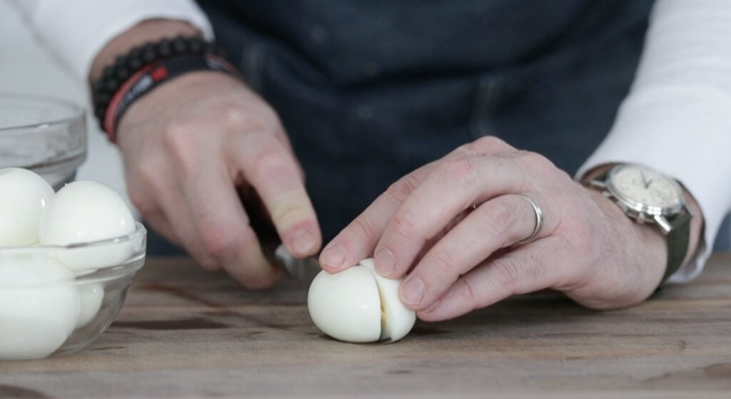 slicing a hard boiled egg in half