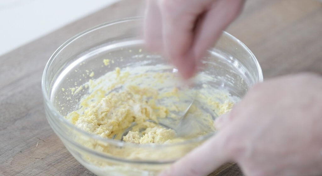whisking a deviled egg filling