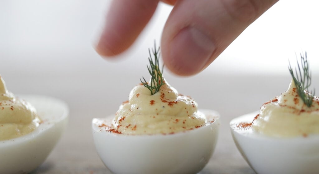 adding fresh dill to a deviled egg