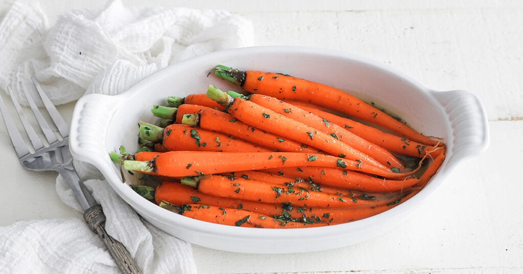 butter glazed baby carrots in a casserole dish
