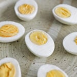 a peeled hard boiled egg sliced in half on a plate