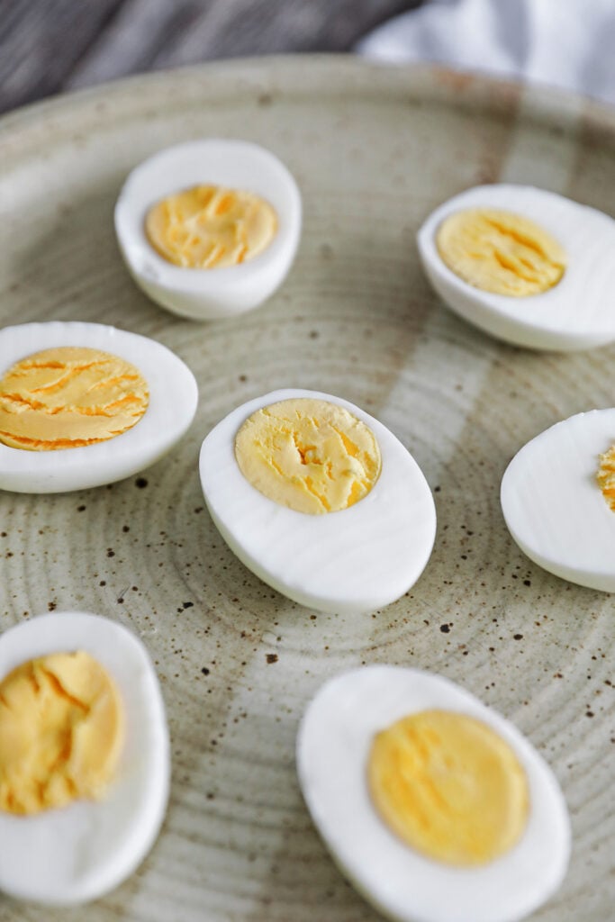 a peeled hard boiled egg sliced in half on a plate