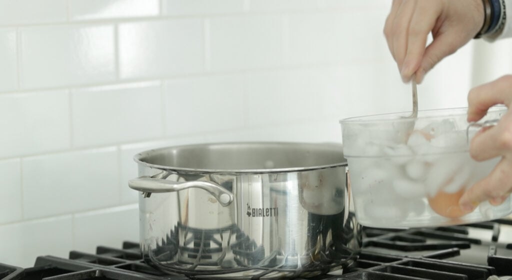 removed boiled eggs from a pot of boiling water into an ice bath