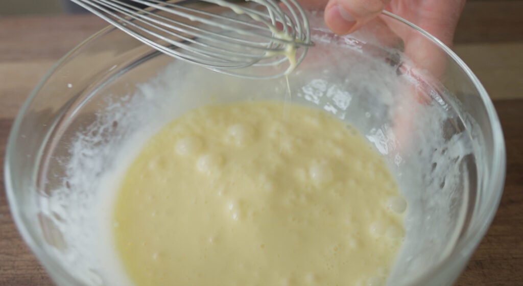 Whisk over a bowl of whisked eggs and cream