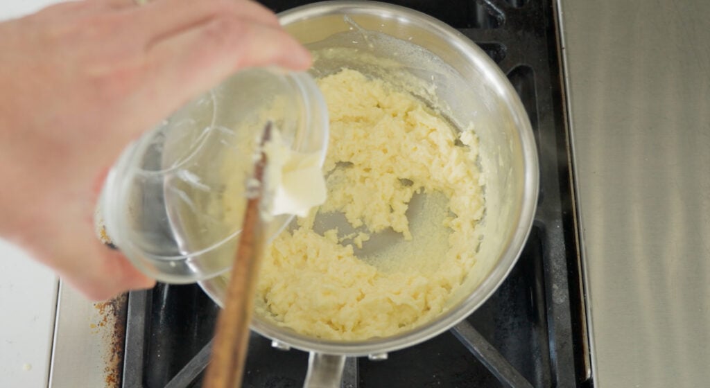 Stirring butter into the cooked eggs