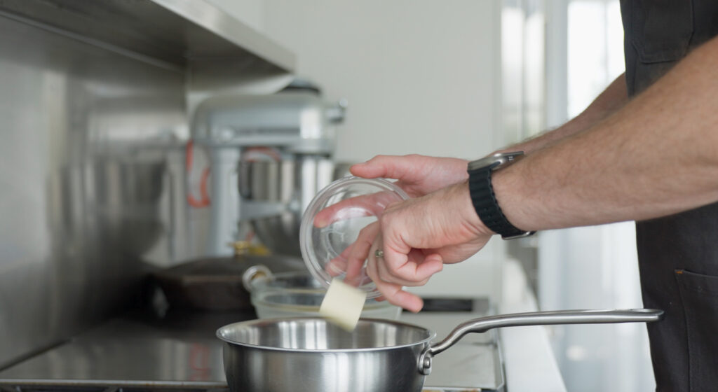 Dropping butter into a pan 