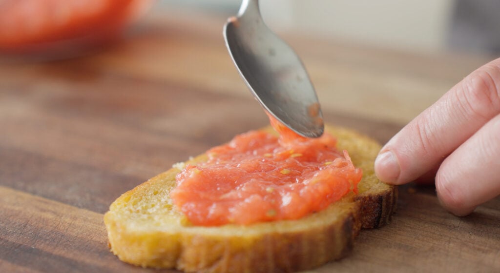 Spooning the tomato mixture onto the slices of toast