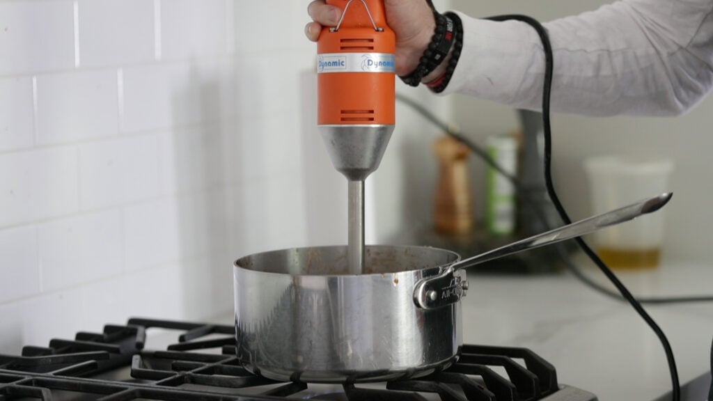 blending a homemade sweet bbq sauce with an emersion blender