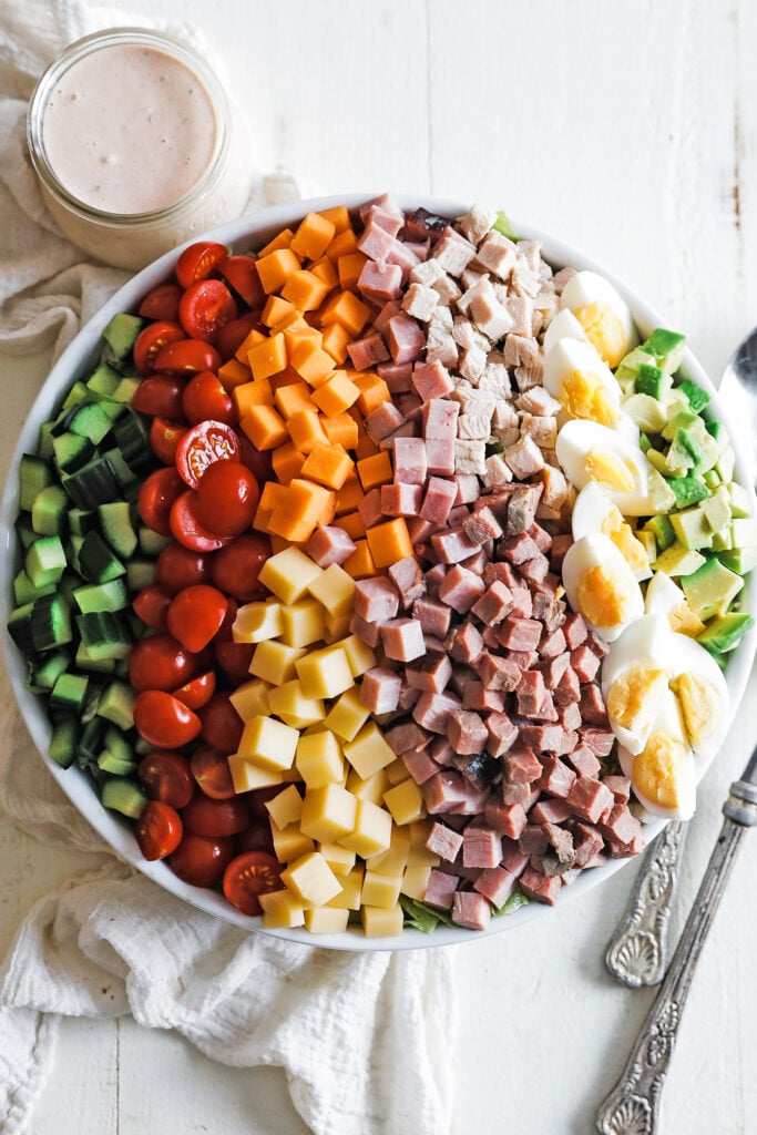 classic chef salad in a bowl with a thousand island dressing on the side