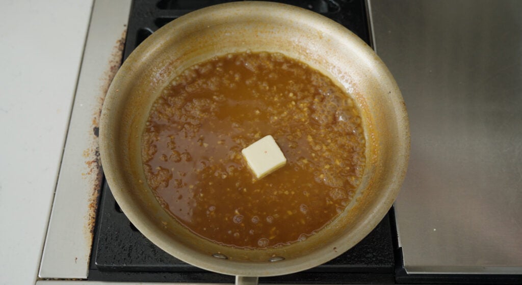 a pat of butter in the middle of the pan of sauce