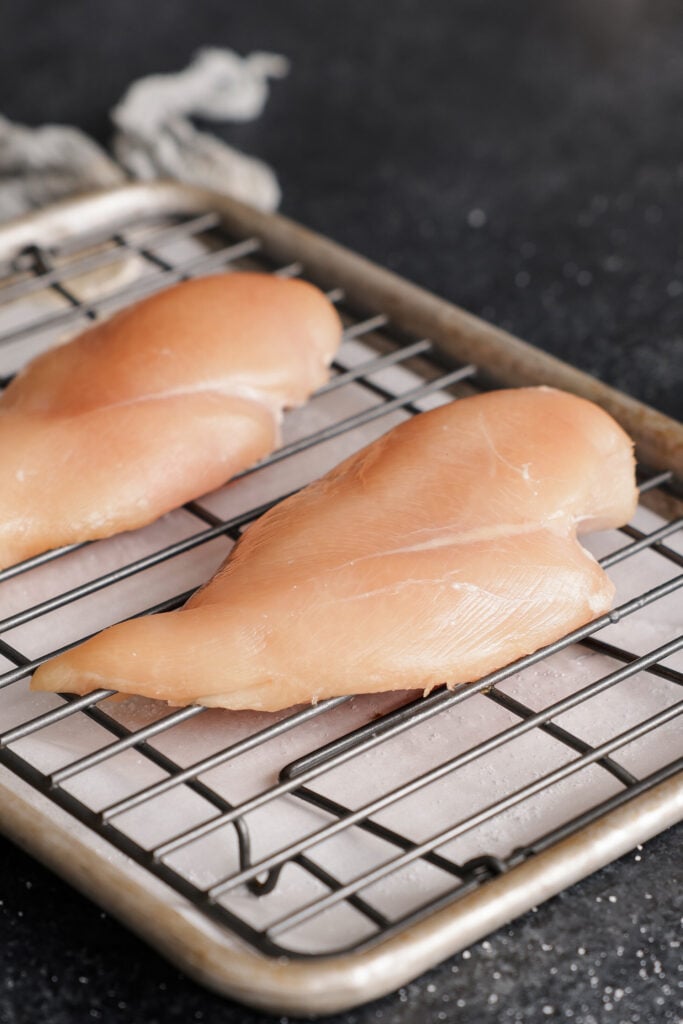 Two chicken breasts ona rack over a sheet tray