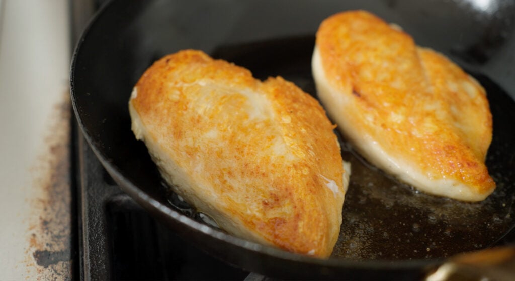 Brown, pan seared chicken breasts still in a pan