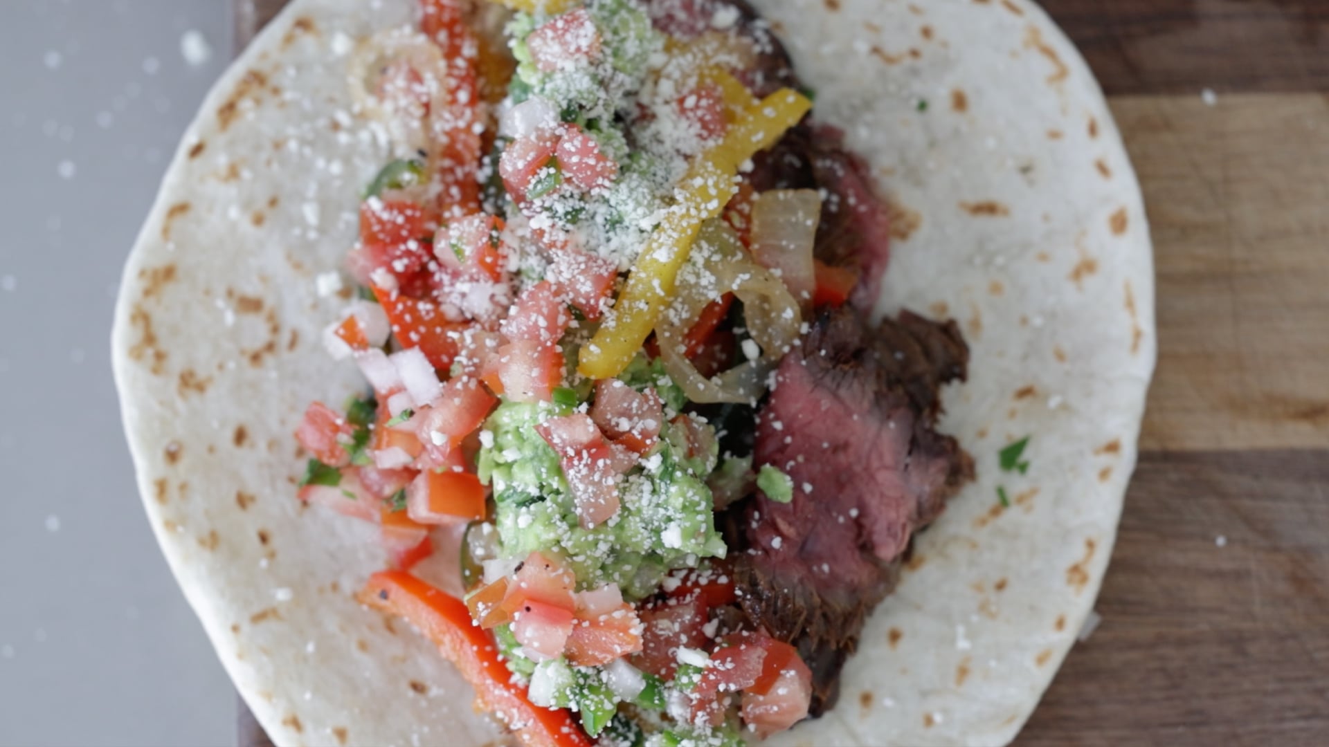 steak fajitas with tortillas, guacamole, and pico de gallo