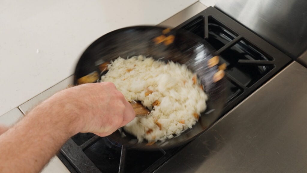 Rice added to pan with garlic and oil