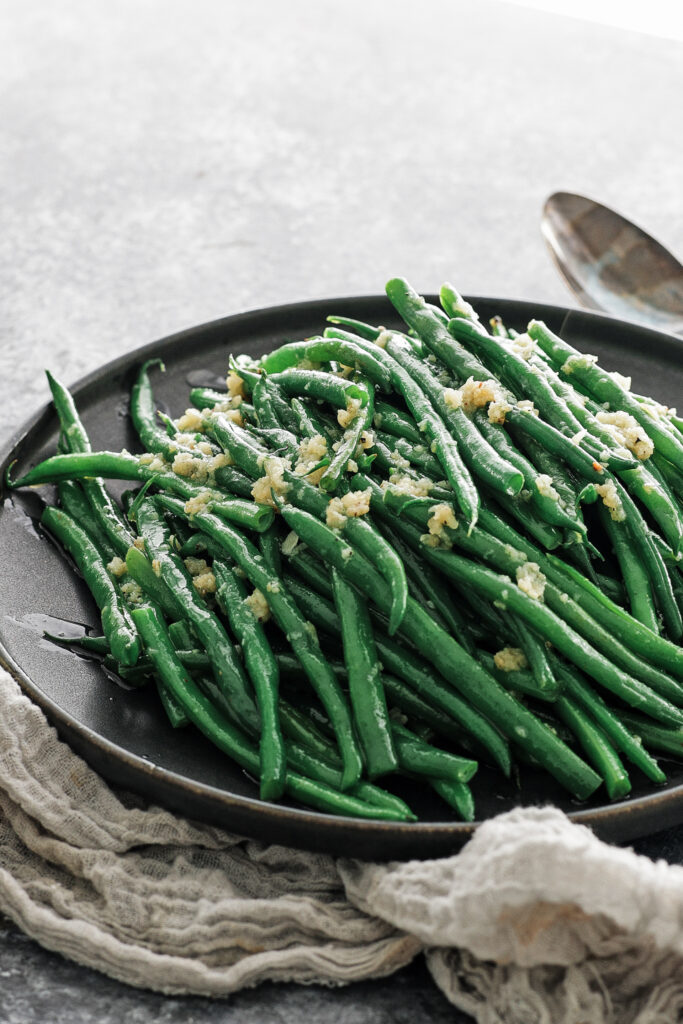 Garlic green beans on a black plate