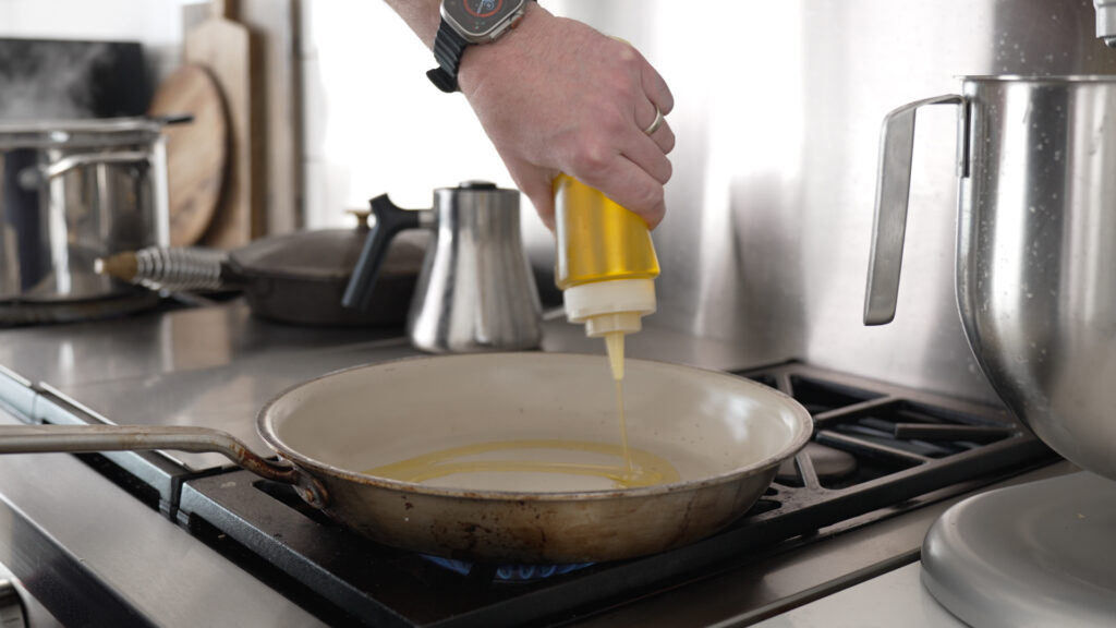 Pouring oil into a skillet on the stove