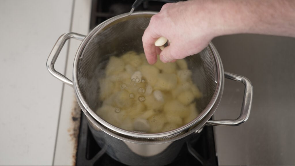 Potatoes in a basket in a large pot of water